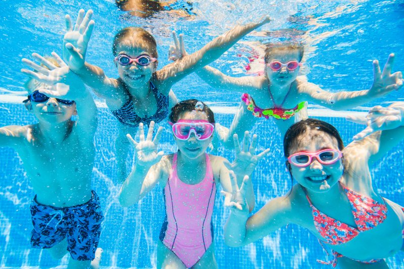 Little kids swimming in a pool underwater